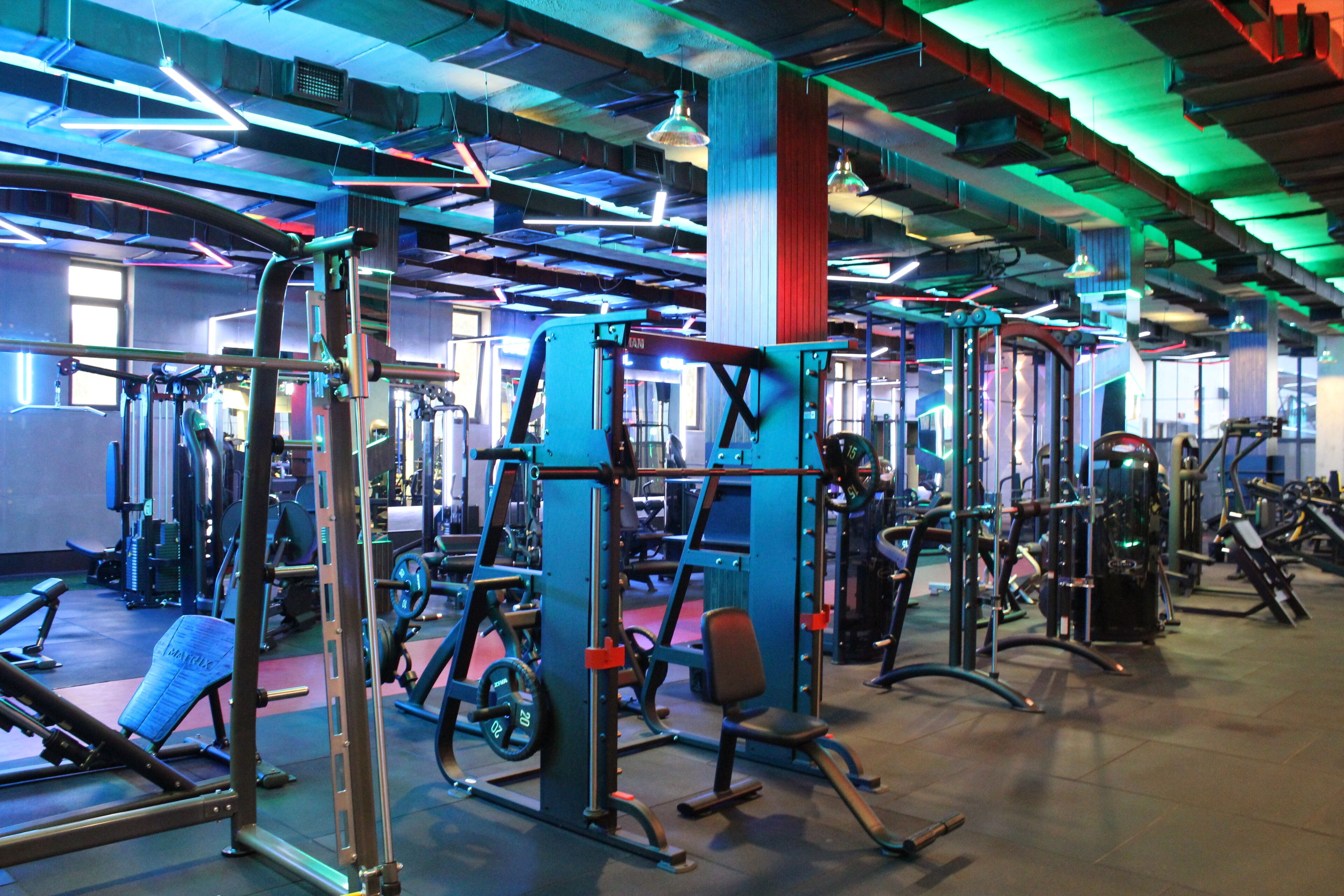 A gym with various exercise equipment, including weight machines and benches.