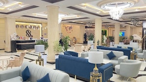A spacious lobby with a reception desk, plush seating areas, and decorative lighting. - Simma Hotel spa and waterpark (Tashkent)