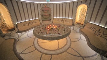 Relax in a serene, candlelit seating area with ornate wall panels and a patterned floor.