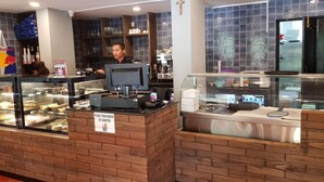 A bakery counter with a sign instructing to place orders at the counter. - Goa Junction Vagator - Apparthotel (Vagator)