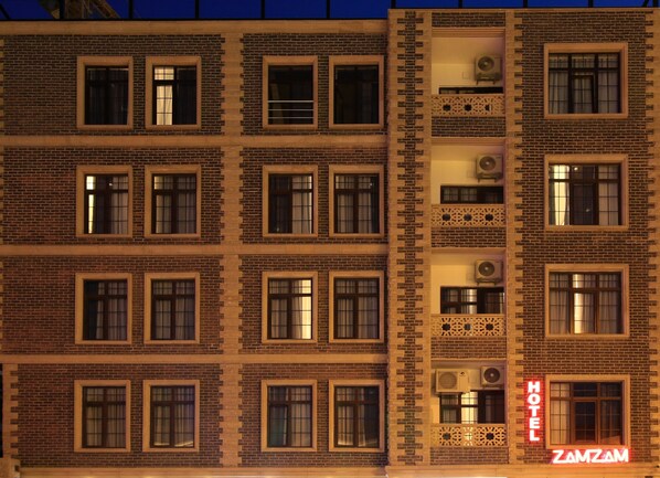 A multi-story hotel building with a brick facade, multiple windows, and a neon sign indicating the name 'ZAMZAM HOTEL'. - ZamZam Hotel (Baku)