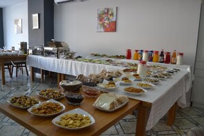 A buffet table with various food items and condiments. - ZamZam Hotel (Baku)