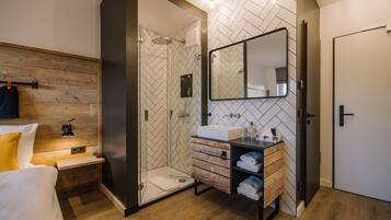 Un baño moderno con ducha, lavabo y espejo.