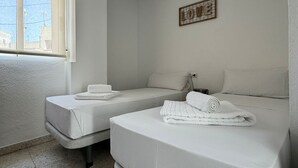 A hotel room with two beds, a window, and a decorative wall piece. - L&G Apartamentos (Benidorm)