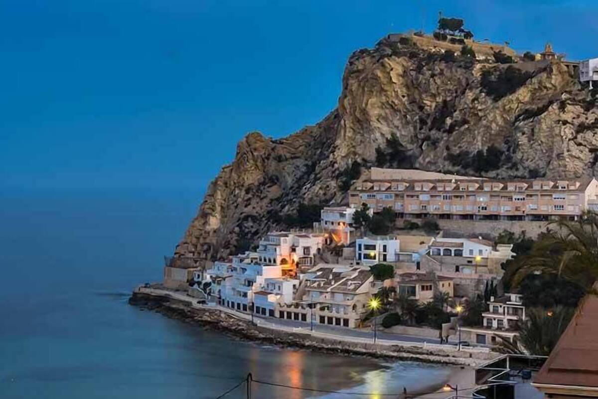 A coastal town with buildings on a rocky cliff overlooking the sea.