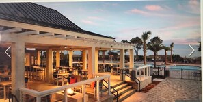 Enjoy alfresco dining in a covered patio area adjacent to the pool.