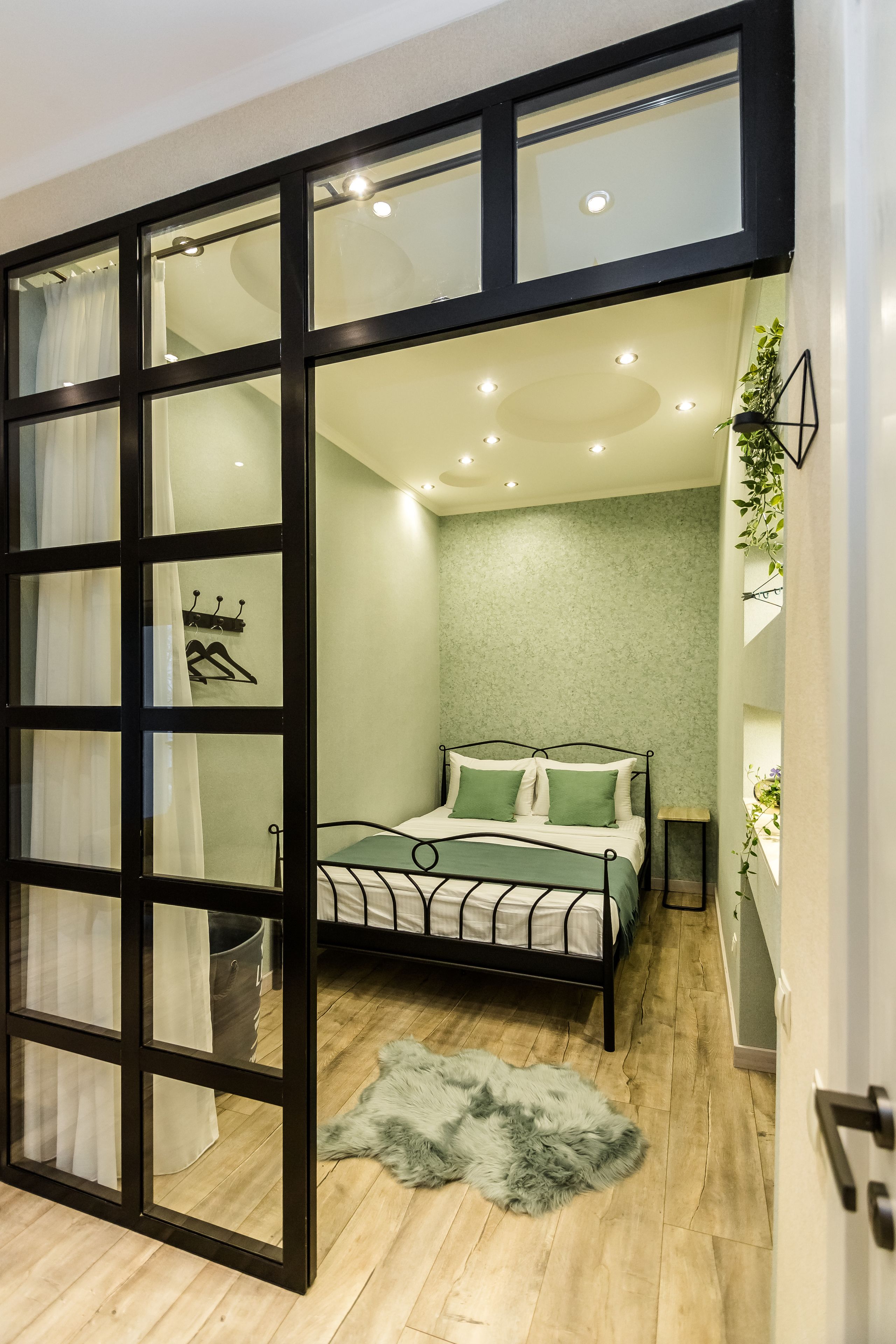 Ein Schlafzimmer mit einem Bett, einem Fellteppich und einem Fenster mit Vorhängen.