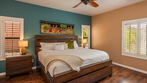 A bedroom with a wooden bed, a ceiling fan, a nightstand with a lamp, and a window with blinds. - Private Home with Courtyard, Walk to Trails & Dining, Pets Welcome! (Sedona)