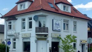A two-story building with a red-tiled roof, multiple windows, and a sign indicating it is a restaurant.