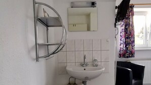 A bathroom with a sink, mirror, and a towel rack.