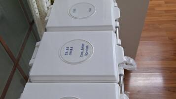 A row of white, rectangular storage units with labels indicating contents such as paper, styrofoam, and cans.