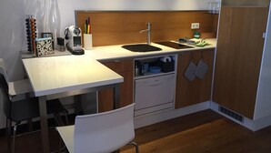A compact kitchen with a white countertop, a sink, a microwave, and a dishwasher. - Panorama52 (Remseck am Neckar)