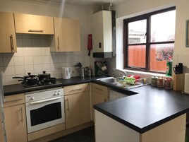Una cocina con estufa, horno, pileta y ventana.