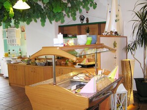 A buffet setup with various food items and a decorative sail. - Pension Dünenhaus (Zempin)