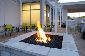 A fire pit area with seating and a covered outdoor space.