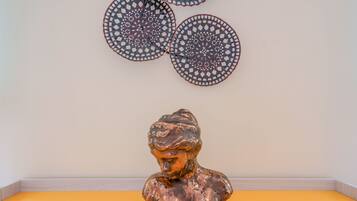 Un busto sobre una superficie amarilla con decoraciones de pared estampadas.