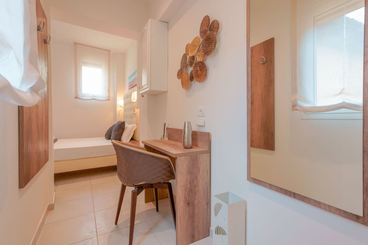 A compact bedroom with a bed, a desk, and a chair.