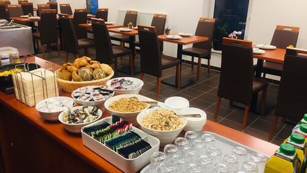 A buffet setup with various food items and beverages in a hotel dining area. - Hotel Mirabell (Erlangen)
