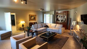 A living room with a sectional sofa, a coffee table, and a bookshelf. - Le Grenier Occitan (Gramazie)