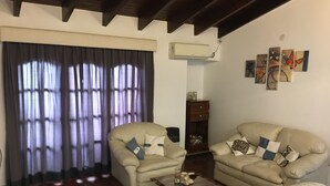 Ein Wohnzimmer mit zwei beigen Sofas, einem Couchtisch und einer dunkelholznen Kommode.