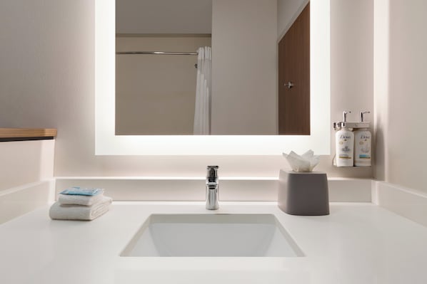A bathroom with a white sink, a mirror, and a towel rack. - Holiday Inn Express & Suites Dalton - Walnut Ave by IHG (Dalton)