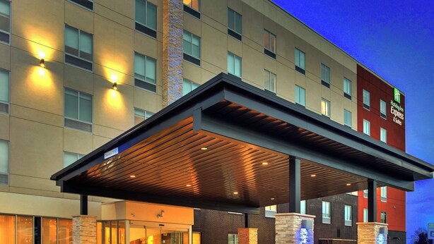 A hotel with a covered entrance, multiple windows, and a sign indicating it's a Holiday Inn Express & Suites. - Holiday Inn Express & Suites Nashville Metrocenter Downtown by IHG (Nashville)