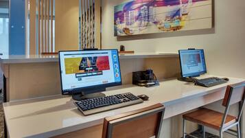 A modern office space with two desktop computers, a keyboard, a mouse, and a chair.