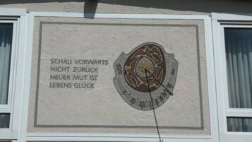 A wall with a compass and German text.