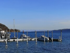 Una marina con barcos amarrados a muelles de madera, agua tranquila y cielo despejado.