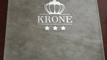 A grey folder with the word "KRONE" and a crown logo, along with three stars.
