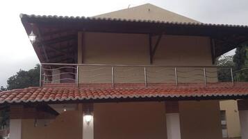 Un edificio a due piani con tetto piatto e un balcone.