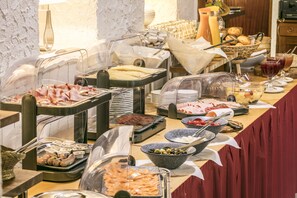 A buffet with various food items and utensils.