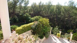 A balcony with a view of a lush garden and dense forest. - La Florentine (Bandol)