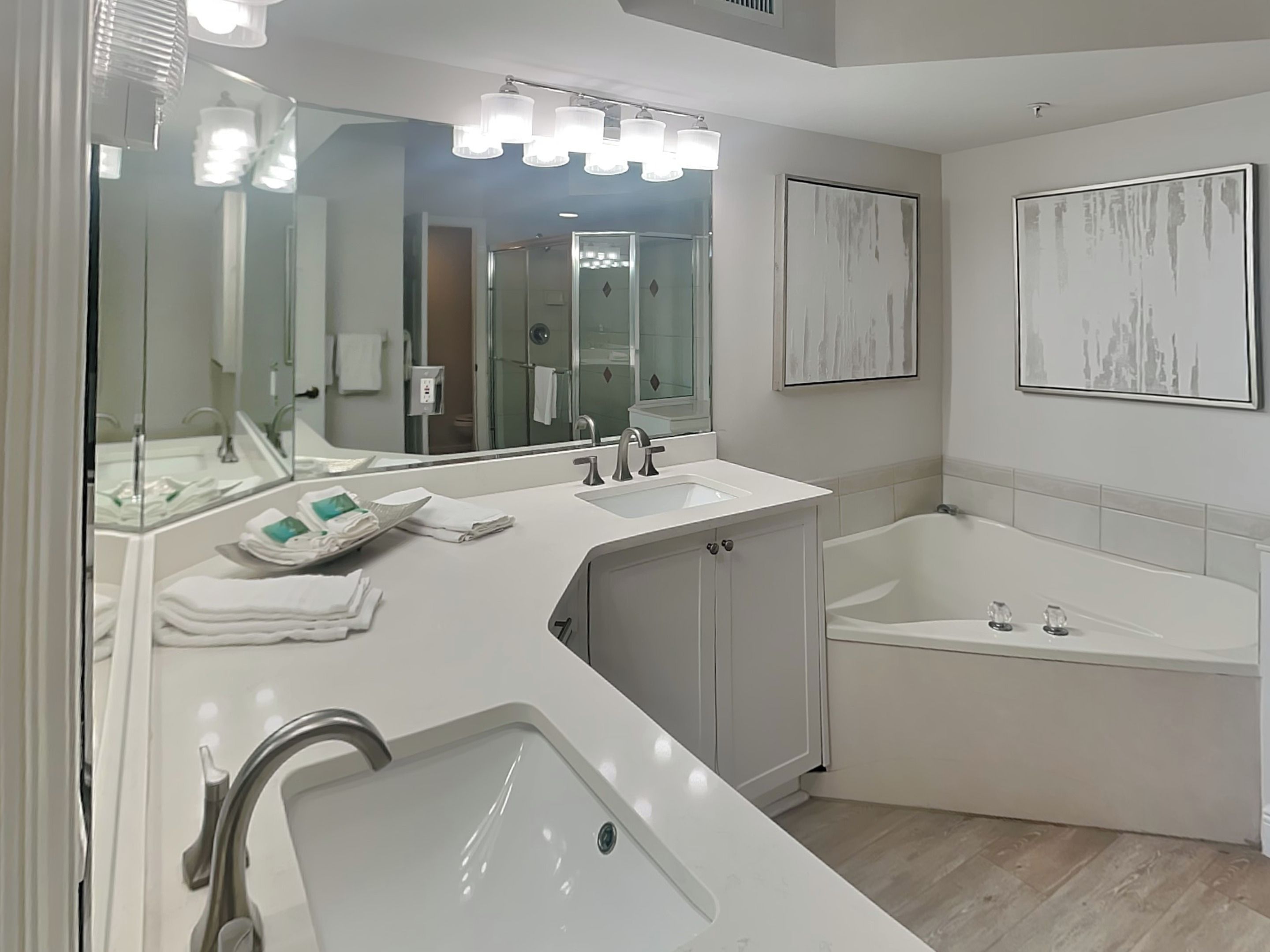 A modern bathroom with a large sink, a bathtub, and a mirror.