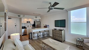 A modern living room with a sofa, coffee table, and a TV. - Lovers Key Resort 403 by Distinctive Beach Rentals (Fort Myers Beach)