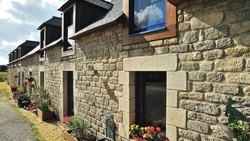 Una hilera de edificios de piedra con múltiples ventanas y macetas con flores.
