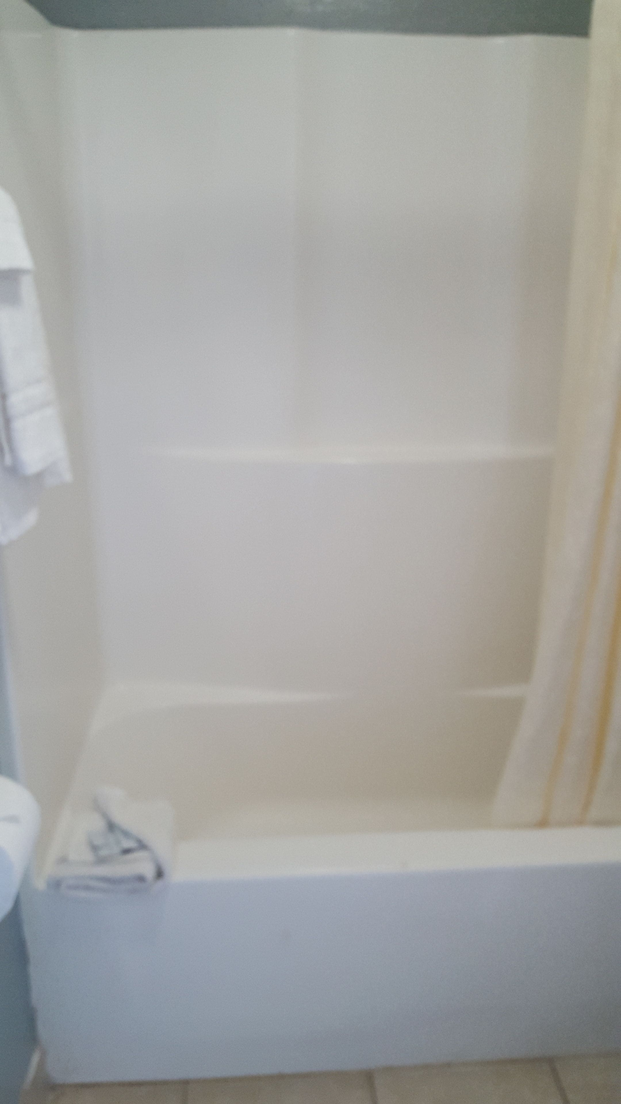 A bathroom with a bathtub, a towel rack, and a toilet.