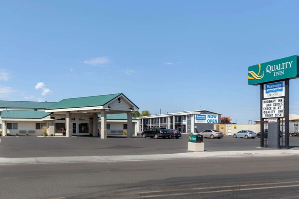 A Quality Inn with a green roof, a gas station, and a sign indicating the availability of high-speed internet.