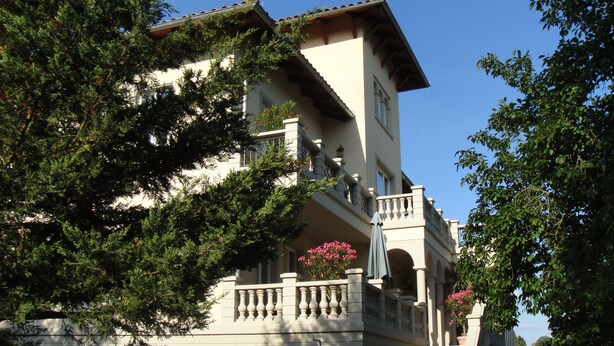 Un immeuble à plusieurs étages doté de balcons, de grandes fenêtres et d’un style architectural traditionnel.