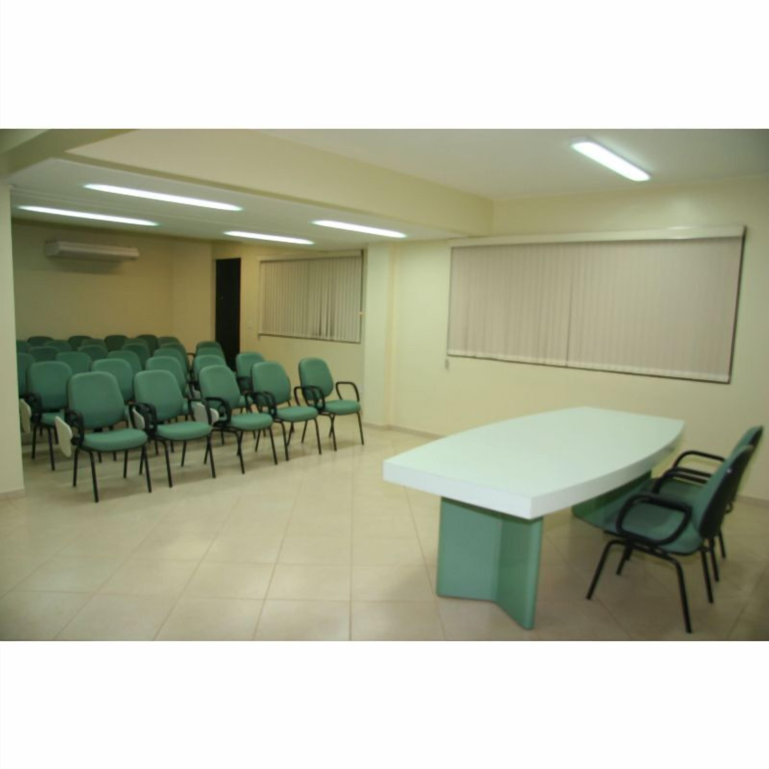 A conference room with a large table and multiple chairs.