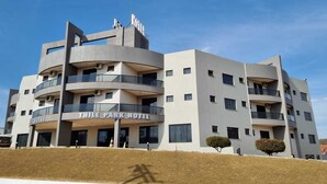 Un hotel de varios pisos con balcones y un cartel que dice "Thile Park Hotel".