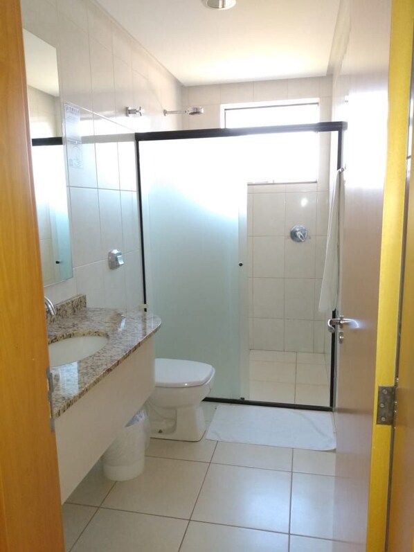 A bathroom with a shower, toilet, and sink.