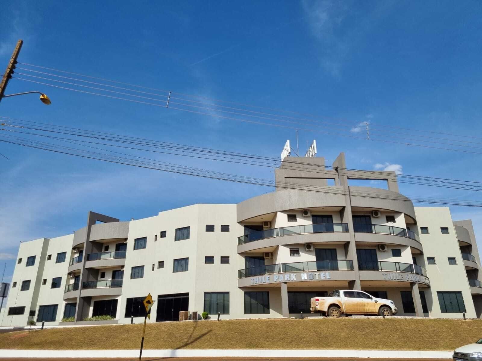 Um hotel de vários andares com design moderno, com varandas e entrada central.