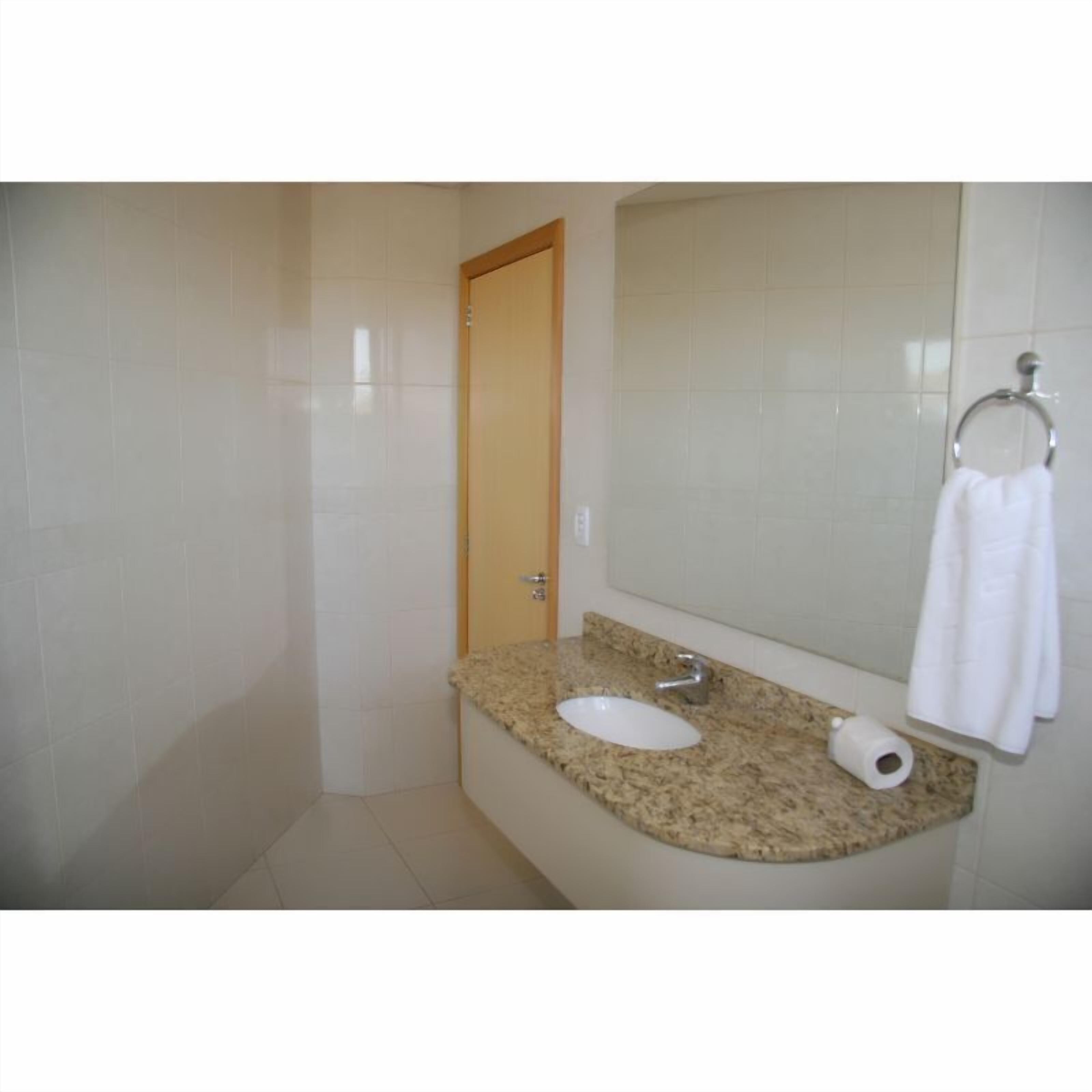 Ein Badezimmer mit Waschbecken, Spiegel und Handtuchhalter.