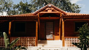 A wooden building with a tiled roof, stone steps leading to a door, and a wooden porch.