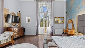 A bedroom with a wooden bed, a television, a dresser, and a window with curtains. - Count Andrassy Luxurious Residence (VI. kerület)