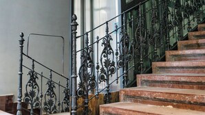 A staircase with ornate metal railings and marble steps. - Count Andrassy Luxurious Residence (VI. kerület)