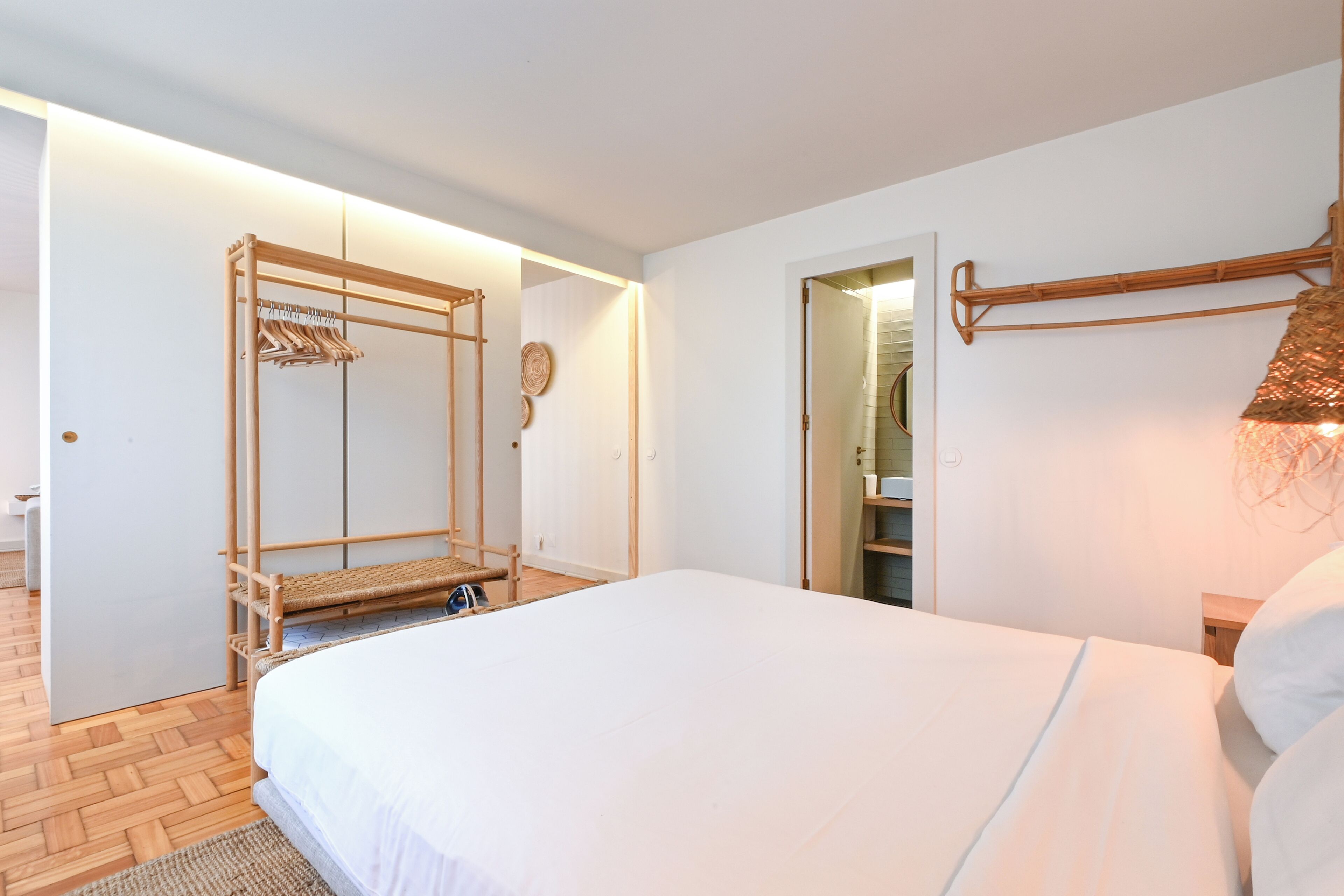 Un dormitorio con cama, armario de madera y espejo.