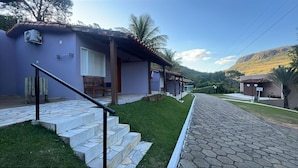 A two-story building with a tiled roof, a covered porch, and a stone staircase leading to the entrance. - Pousada do Rio Turvo (Capitólio)