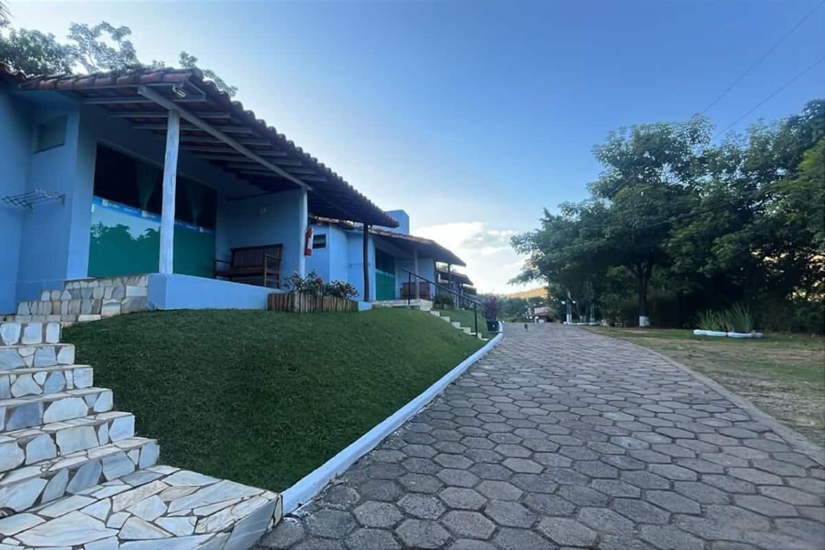 Un edificio con fachada azul, escalones de piedra que conducen a un porche y un camino empedrado.